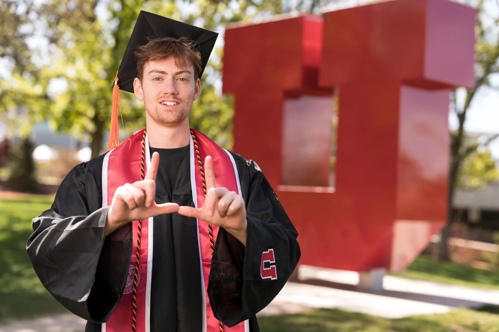 Alex Murdock wearing graduation robes at the University of Utah.